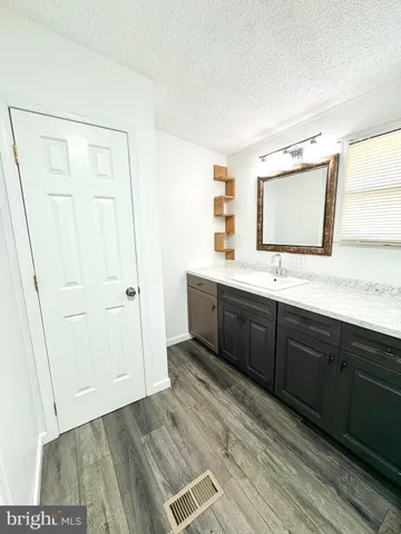 a spacious bathroom with a double vanity sink a mirror and a