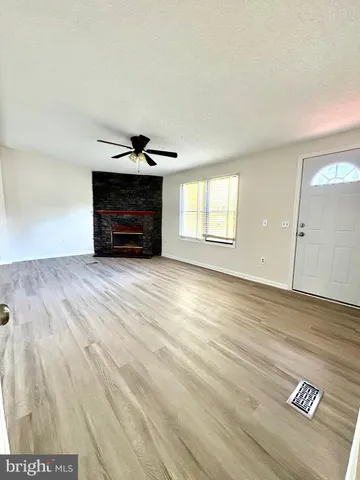 an empty room with windows and fireplace