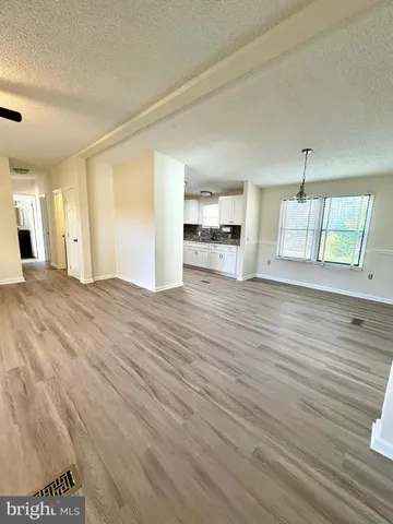 a view of a kitchen with wooden floor and electronic appliances