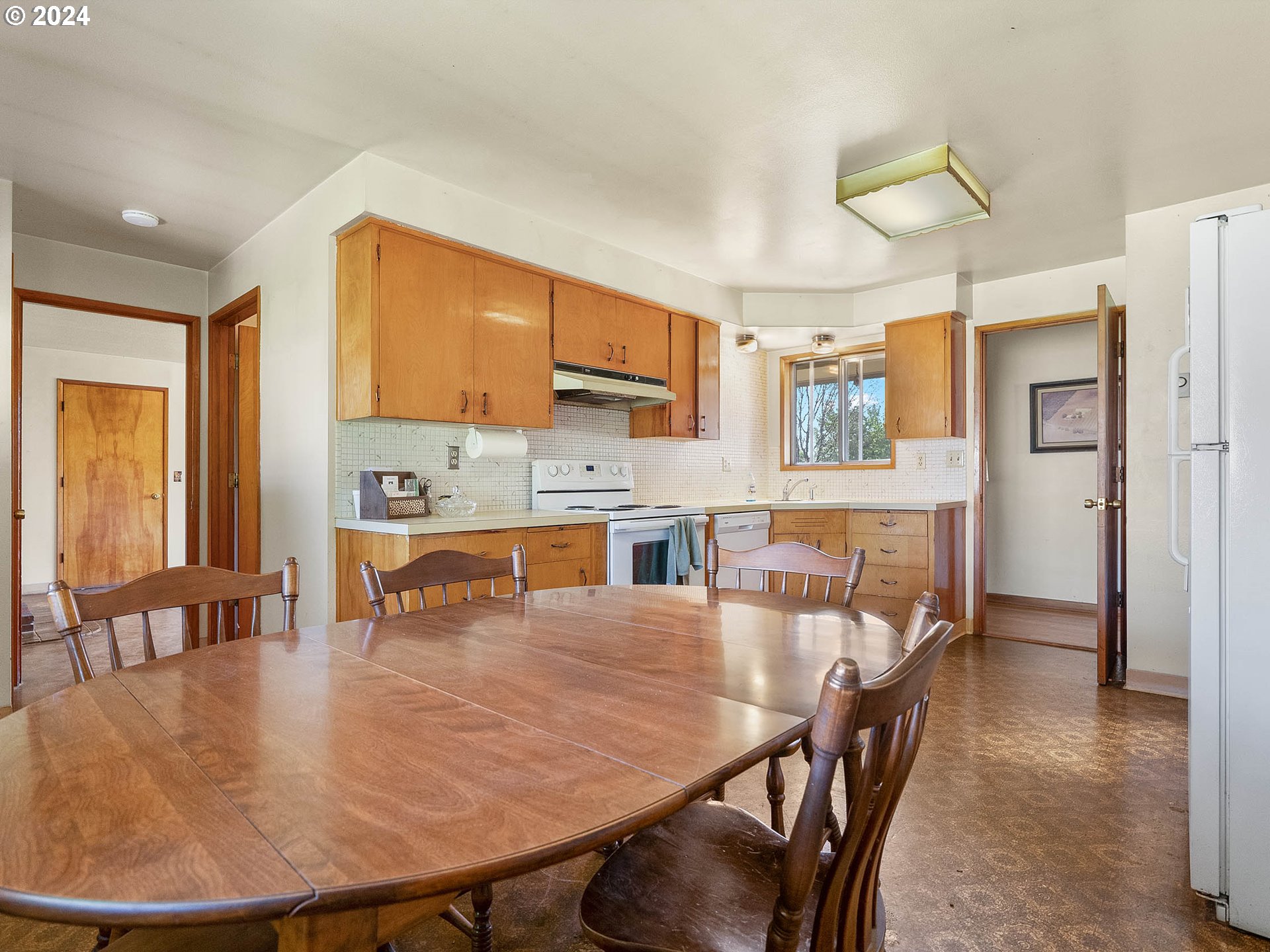 23865 Southwest Tile Flat Road Hillsboro, OR 97123 - Photo 11 of 36 a dining table chairs and a refrigerator in a kitchen