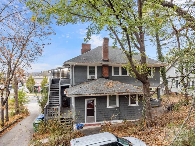 a front view of a house with a tree