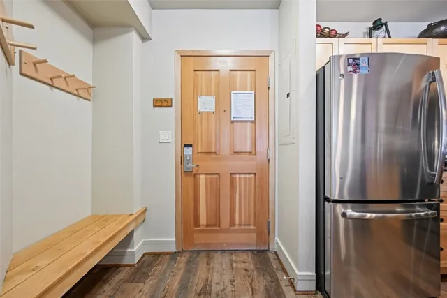 a view of a kitchen with refrigerator and wooden floor