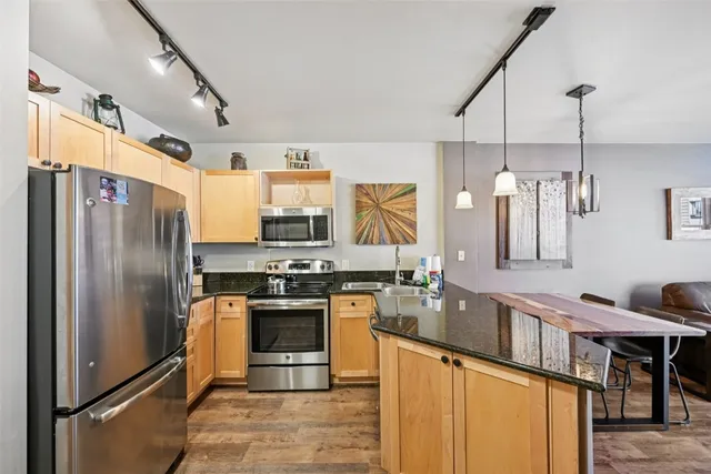a kitchen with stainless steel appliances granite countertop a stove refrigerator sink and cabinets