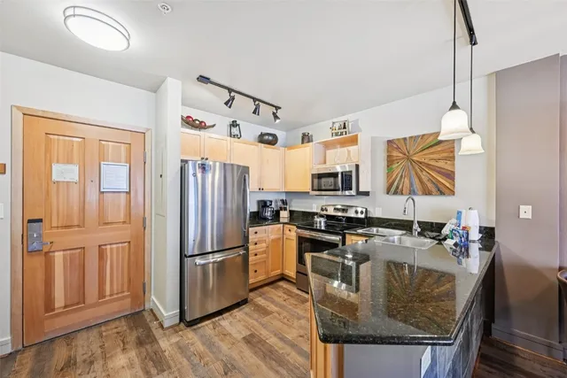 a kitchen with stainless steel appliances granite countertop a refrigerator stove and sink
