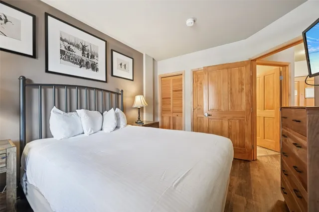 a bedroom with a large bed and a chandelier