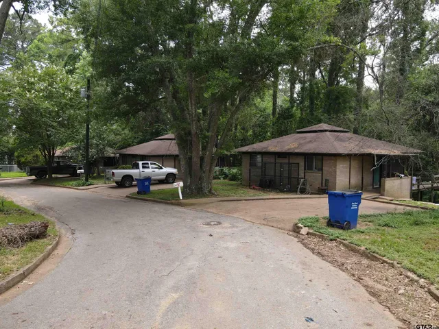 a car parked in front of a house next to a yard