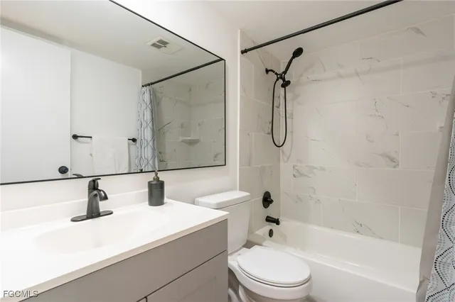a bathroom with a granite countertop sink toilet a shower and a mirror