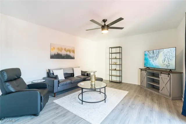 a living room with furniture and a wooden floor