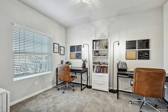 a view of a workspace with furniture and a window