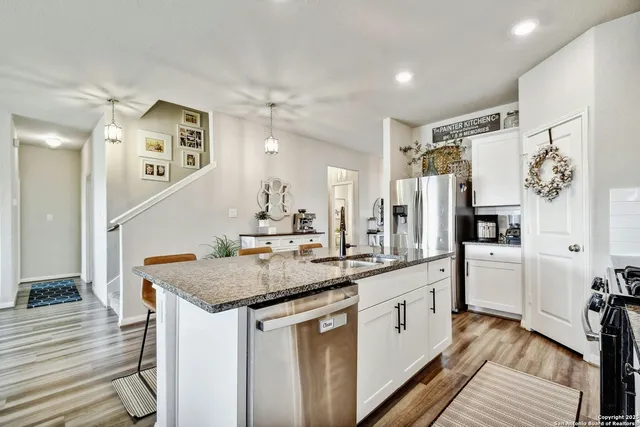 a kitchen with stainless steel appliances granite countertop a sink stove and refrigerator