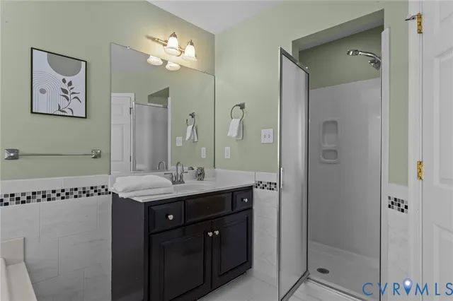 a bathroom with a granite countertop sink a large mirror and a shower