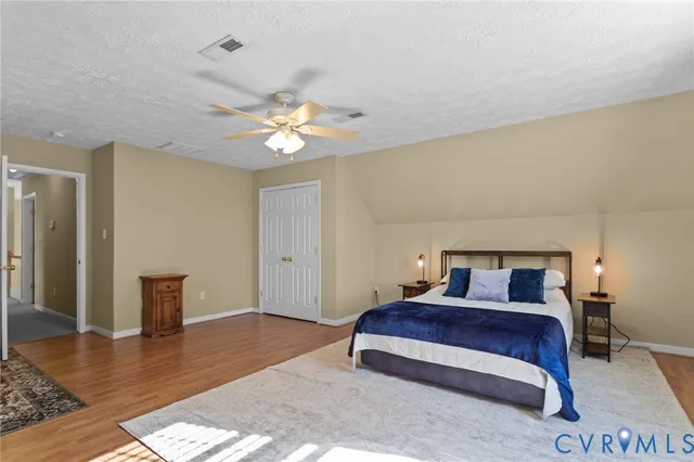 a bedroom with a large bed and a chandelier