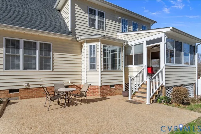 a view of a house with a patio and a yard