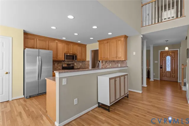 a kitchen with stainless steel appliances granite countertop a refrigerator a sink a stove and oven