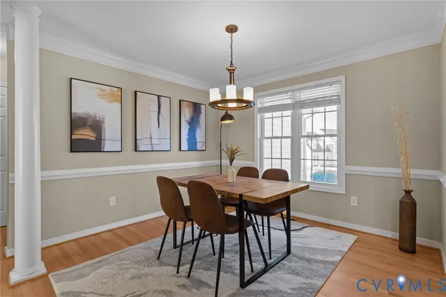 a dining room with furniture a chandelier and wooden floor
