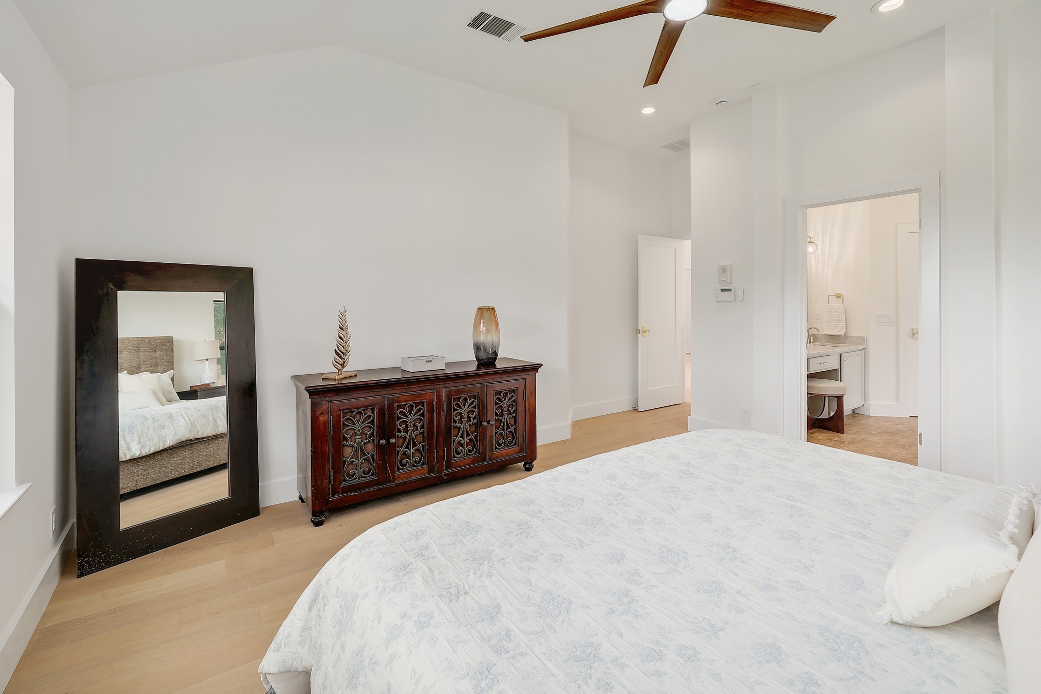 7705 Jester Boulevard Austin, TX 78730 - Photo 14 of 36 Bright hardwood floors and a ceiling fan create a serene primary bedroom retreat.