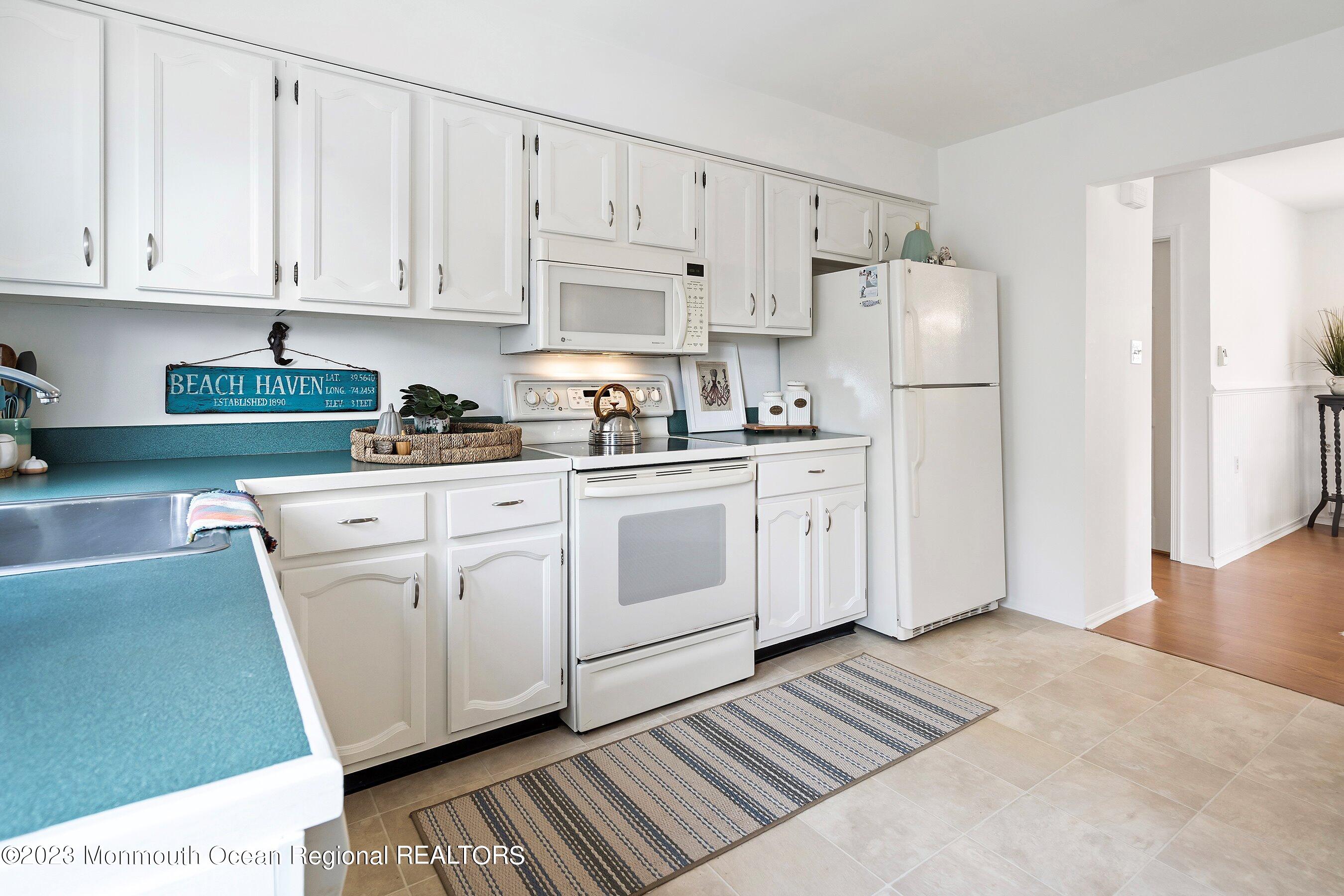60 Sycamore Access Road, Unit 29 Manahawkin, NJ 08050 - Photo 9 of 24 a kitchen with white cabinets and white appliances