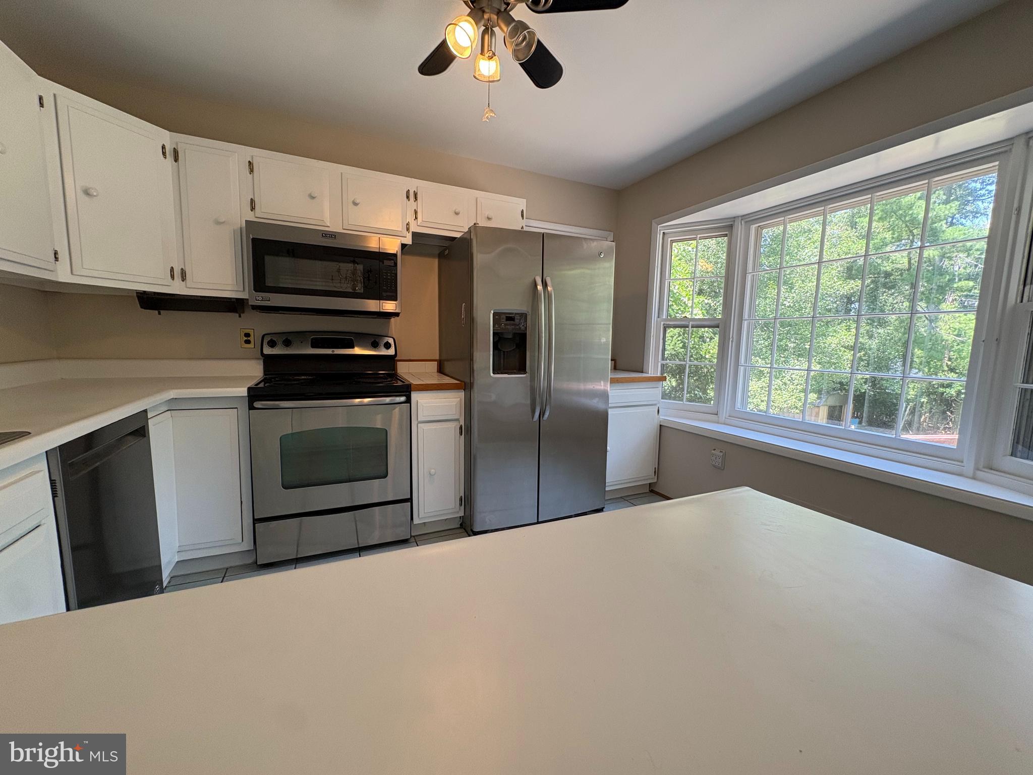 1554 Long Point Road Pasadena, MD 21122 - Photo 11 of 27 a kitchen with stainless steel appliances a stove top oven a sink with a dining table and chairs