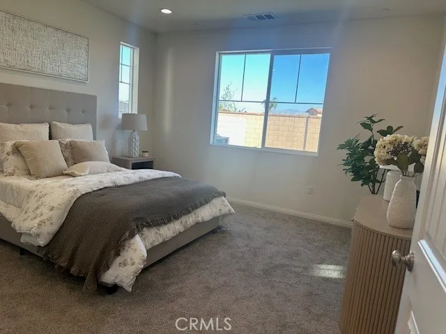 a bed sitting in a bedroom next to a window