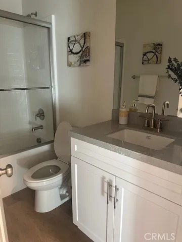a bathroom with a granite countertop toilet sink and mirror