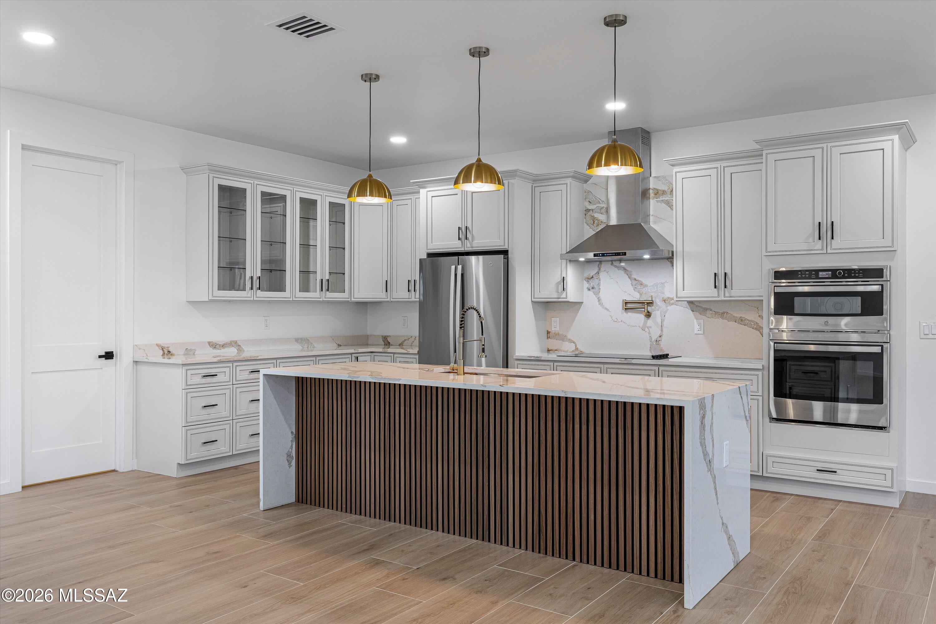 5259 East Fort Lowell Road Tucson, AZ 85712 - Photo 12 of 50 a open kitchen with stainless steel appliances granite countertop a sink a stove and a wooden floor