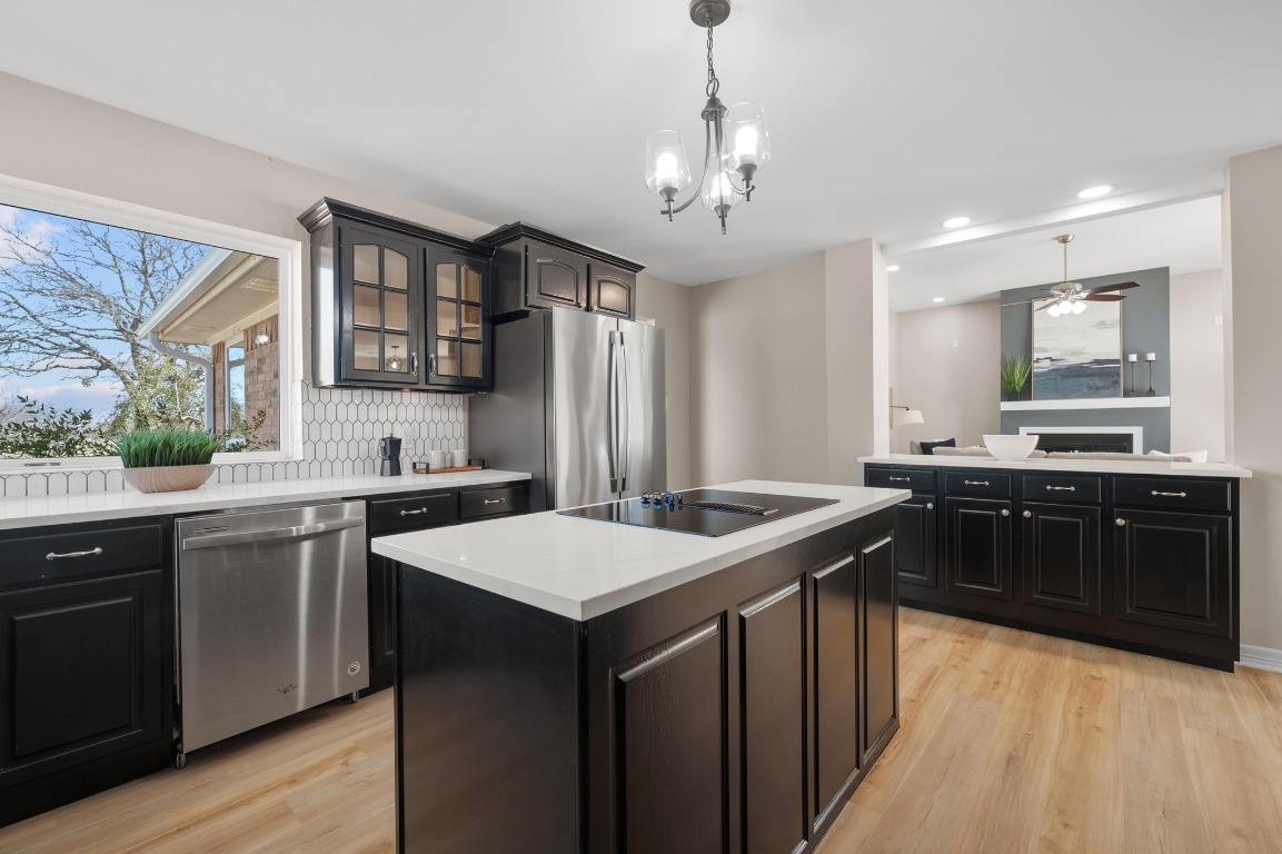 201 Young Ranch Road Georgetown, TX 78633 - Photo 11 of 40 a kitchen with a stove a sink a kitchen island with chairs and wooden floor