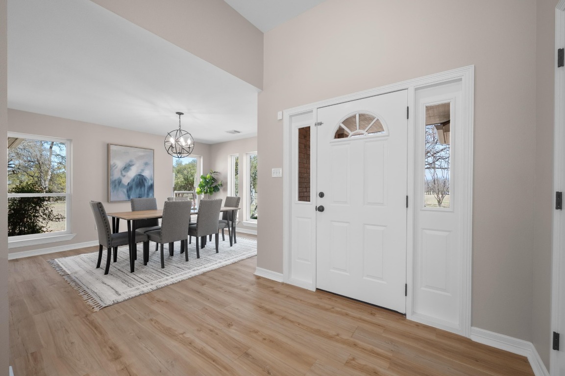 201 Young Ranch Road Georgetown, TX 78633 - Photo 3 of 40 a view of a dining room with furniture a chandelier and wooden floor