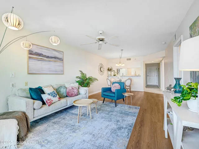 a dining room with furniture a chandelier and wooden floor