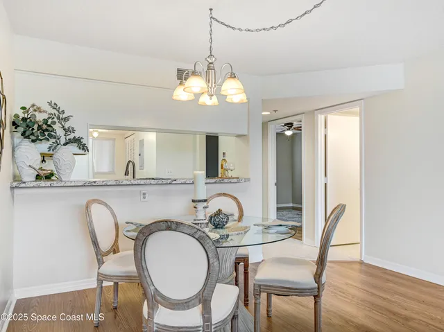 a dining room with furniture a chandelier and wooden floor