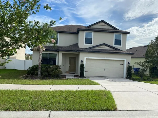 a front view of a house with a yard and garage