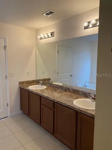a bathroom with a granite countertop sink and a mirror