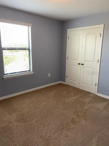 an empty room with windows and closet