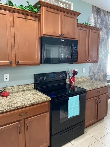 a kitchen with granite countertop a stove and cabinets