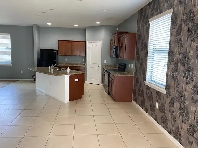 a kitchen with stainless steel appliances a stove a sink a microwave and a refrigerator