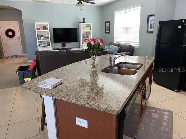 a kitchen with granite countertop a sink and a refrigerator