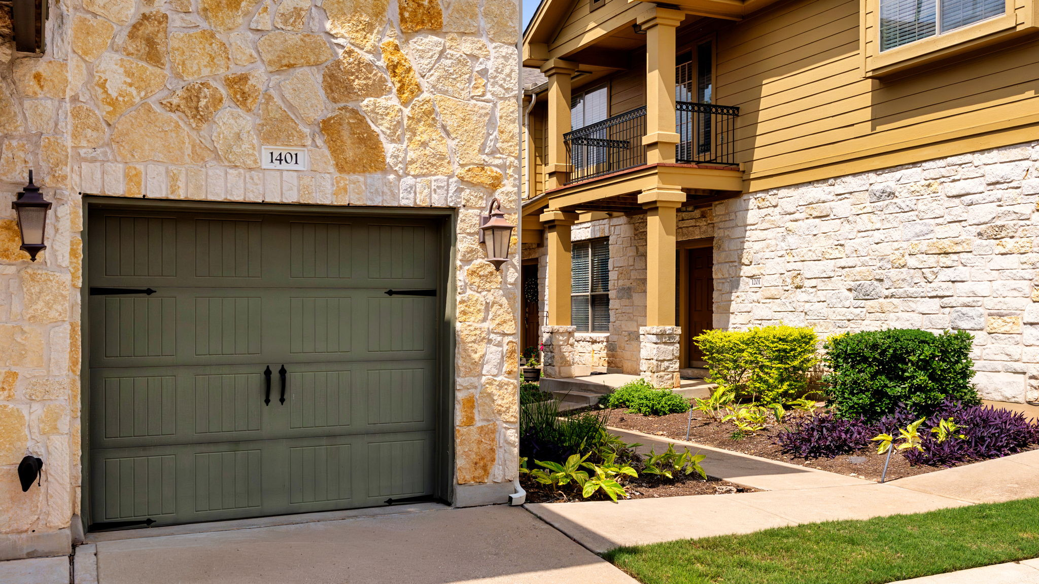 14815 Avery Ranch Boulevard, Unit 1401 Austin, TX 78717 - Photo 5 of 38 Stone veneer and horizontal siding exterior featuring a decorative garage door with exterior sconces