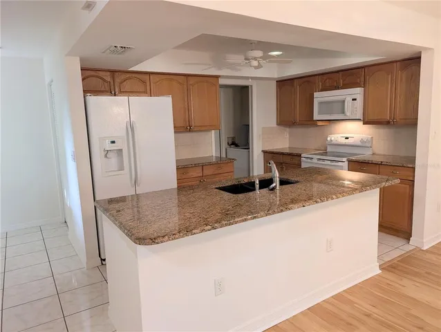 a kitchen with stainless steel appliances granite countertop a sink refrigerator and cabinets