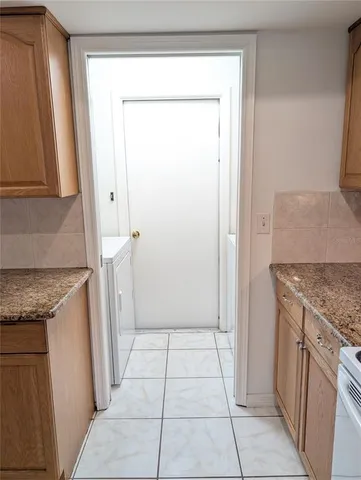 a view of a kitchen with refrigerator and window