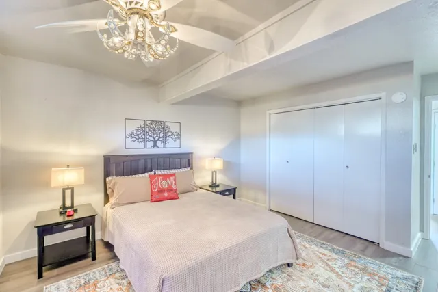 a bedroom with a large bed and a chandelier