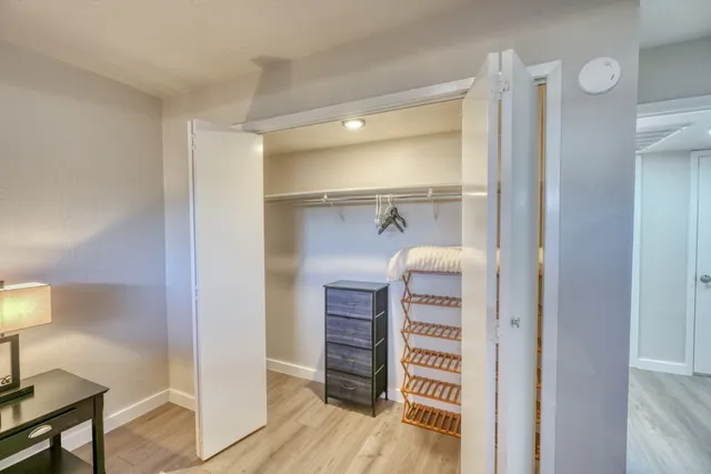 a view of walk in closet with wooden floor