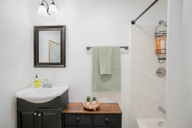 a bathroom with a sink a toilet and shower