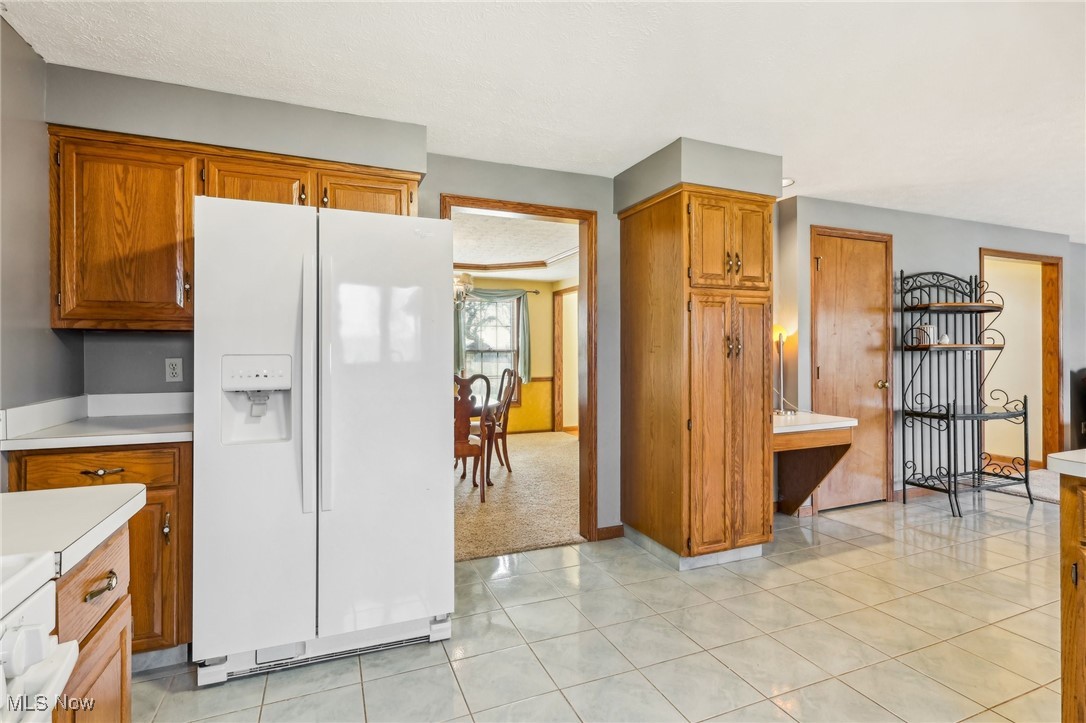 3530 State Road Medina, OH 44256 - Photo 15 of 47 Kitchen featuring light tile patterned flooring, white fridge with ice dispenser, and a textured ceiling