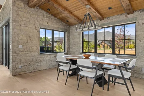 a dining room with furniture a chandelier and wooden floor