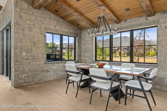 a dining room with furniture a chandelier and wooden floor