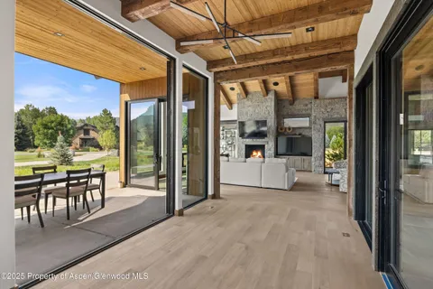 a view of a porch with chairs and floor to ceiling window