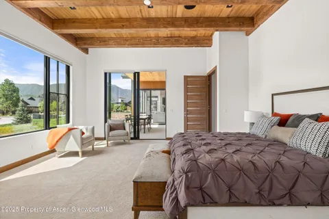 a spacious bedroom with a bed and large windows