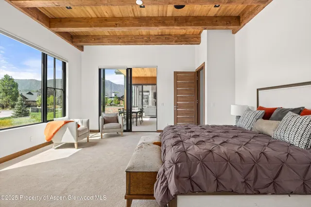 a spacious bedroom with a bed and large windows