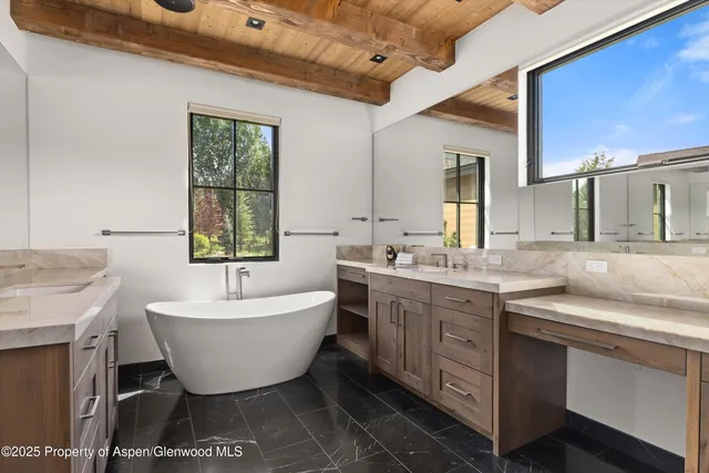a spacious bathroom with a bathtub sink and mirror