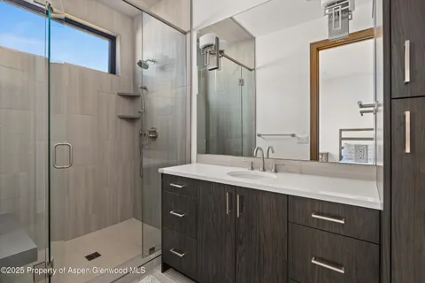 a bathroom with a shower sink and mirror