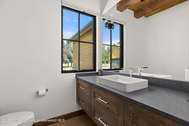 a bathroom with a granite countertop sink mirror vanity and toilet